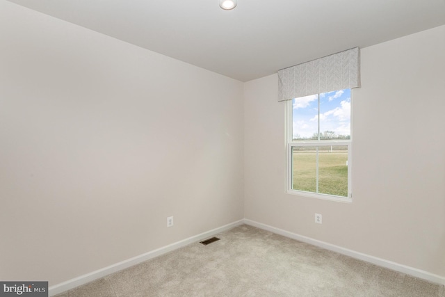 unfurnished room featuring light carpet