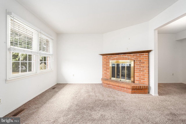 unfurnished living room with a fireplace and carpet