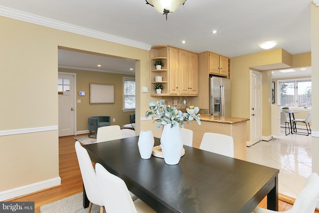 dining area featuring ornamental molding and light hardwood / wood-style floors