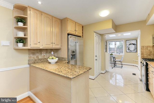 kitchen featuring light brown cabinetry, tasteful backsplash, kitchen peninsula, stainless steel appliances, and light stone countertops