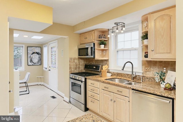 kitchen featuring sink, light tile patterned floors, stainless steel appliances, and light brown cabinets