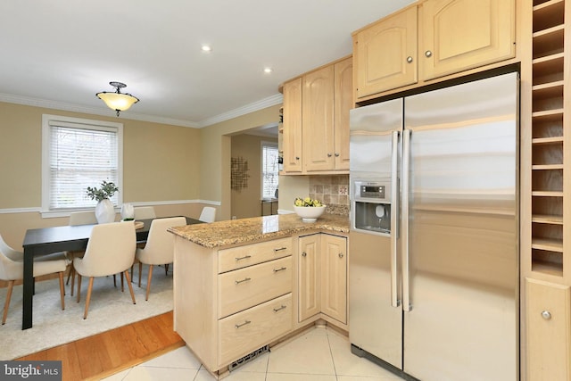 kitchen featuring ornamental molding, light stone countertops, light brown cabinets, and stainless steel fridge