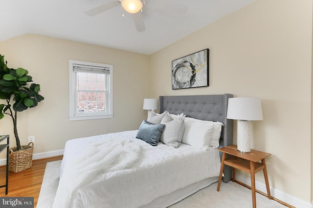 bedroom with ceiling fan, lofted ceiling, and hardwood / wood-style floors