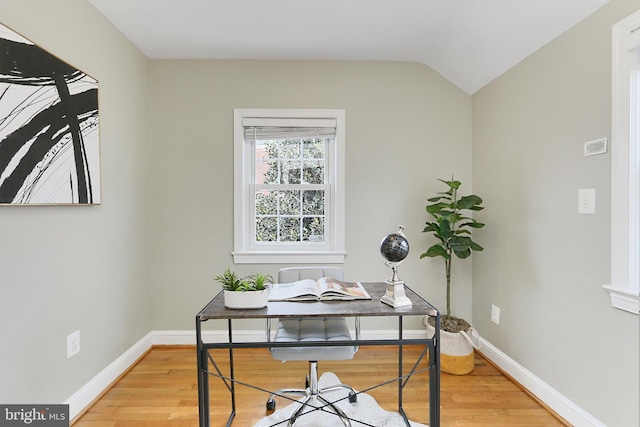 office space featuring vaulted ceiling and light hardwood / wood-style flooring