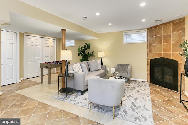 living room with light tile patterned floors and a tile fireplace