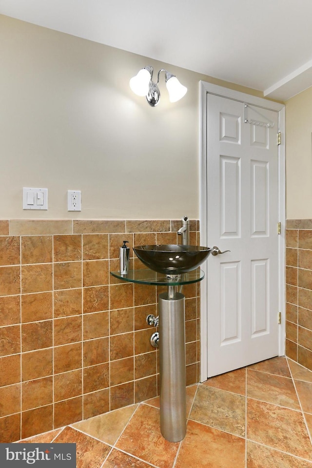 bathroom featuring tile walls and sink