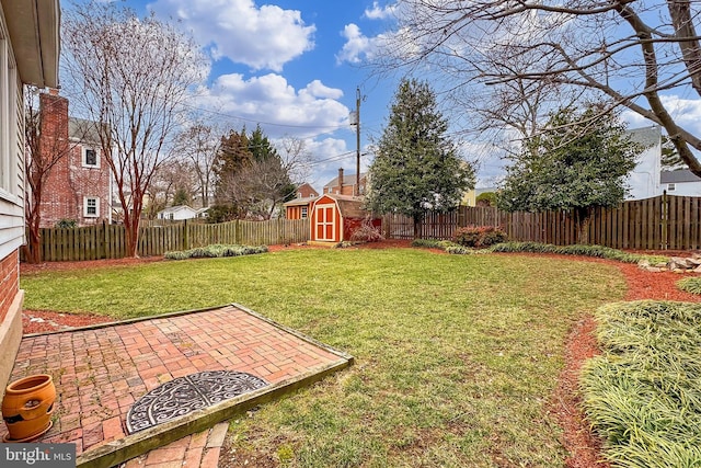 view of yard featuring a shed and a patio area