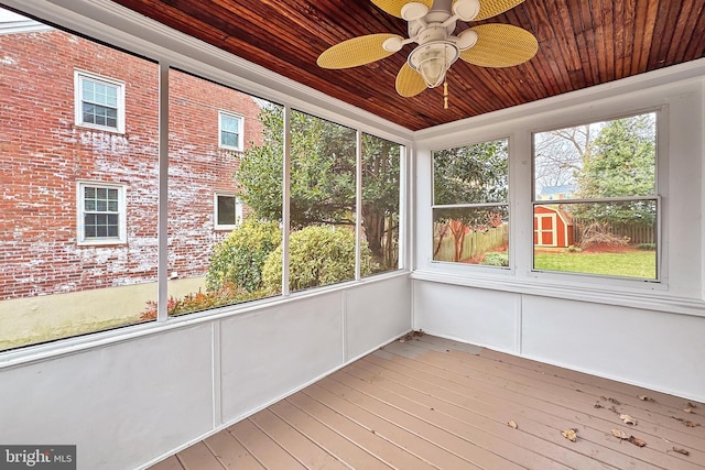 unfurnished sunroom with plenty of natural light, wooden ceiling, and ceiling fan