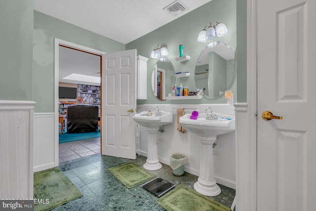 bathroom with tile patterned flooring, sink, and a textured ceiling