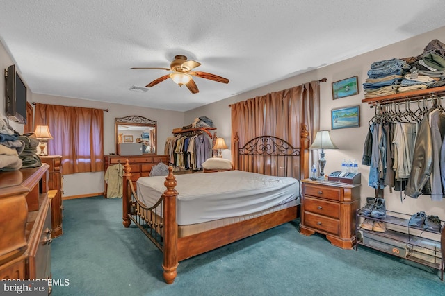 bedroom featuring ceiling fan, a textured ceiling, and dark carpet