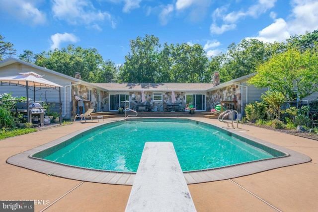 view of swimming pool featuring a patio, a gazebo, and a diving board