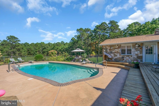 view of pool with a diving board and a patio