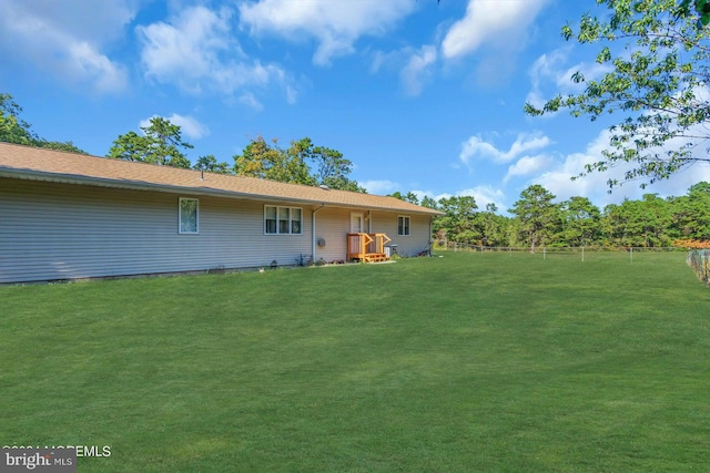 rear view of property featuring a lawn