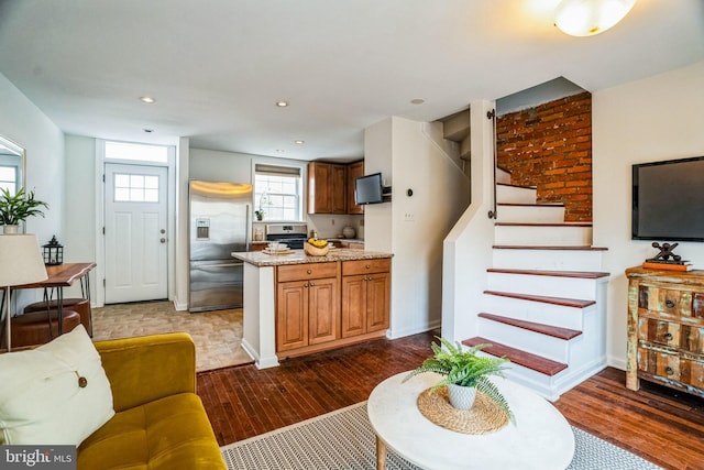 living area with recessed lighting, dark wood-style flooring, baseboards, and stairs