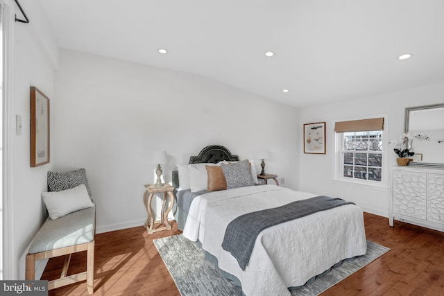 bedroom featuring baseboards, wood finished floors, and recessed lighting