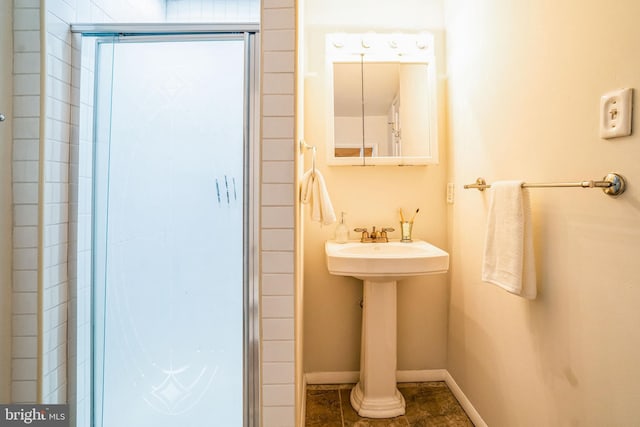 bathroom featuring an enclosed shower and baseboards