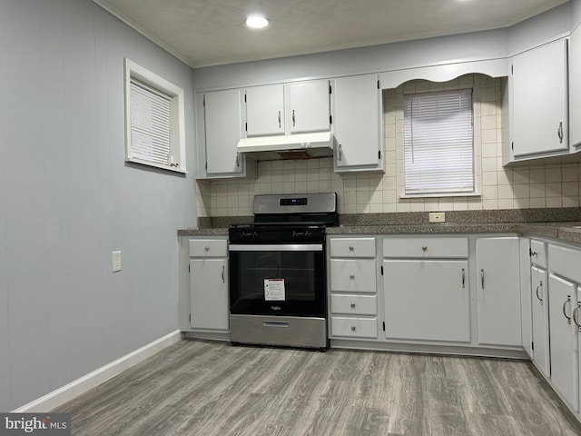 kitchen with white cabinets, decorative backsplash, light hardwood / wood-style flooring, and stainless steel range oven