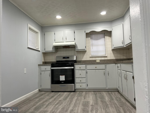 kitchen with hardwood / wood-style flooring, tasteful backsplash, ornamental molding, white cabinets, and stainless steel range with gas cooktop