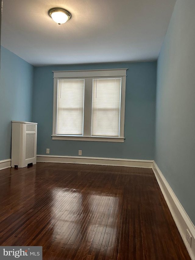 spare room featuring dark wood-type flooring