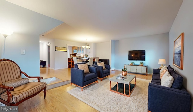 living room with light hardwood / wood-style flooring and a notable chandelier