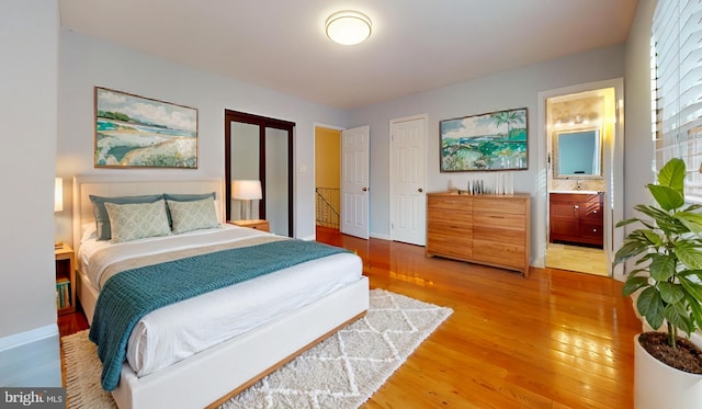 bedroom featuring ensuite bathroom and hardwood / wood-style floors