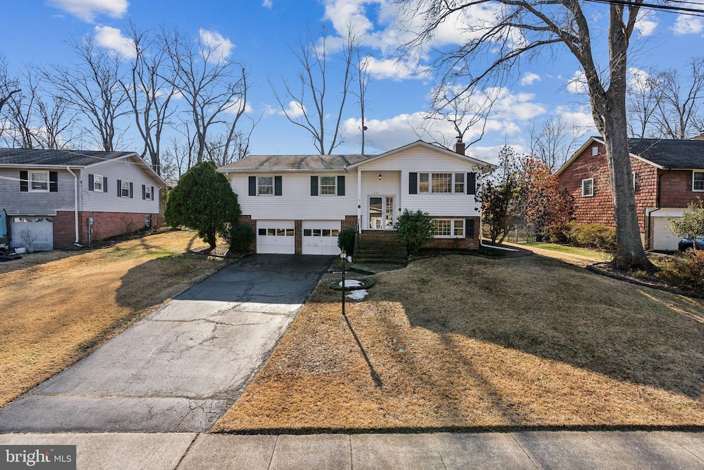 raised ranch with a garage and a front lawn