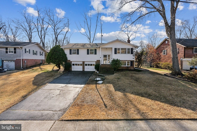 split foyer home with a garage and a front yard