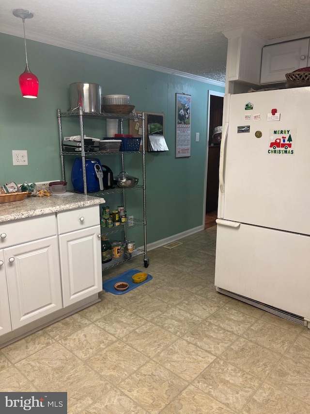 30 Foggy Bottom Ln, Berkeley Springs, WV 25411 - kitchen with crown molding, decorative light fixtures, a textured ceiling, white fridge, and white cabinets