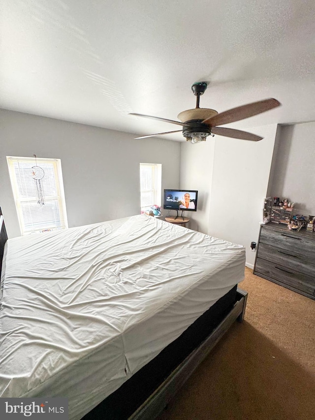 carpeted bedroom featuring a textured ceiling and ceiling fan