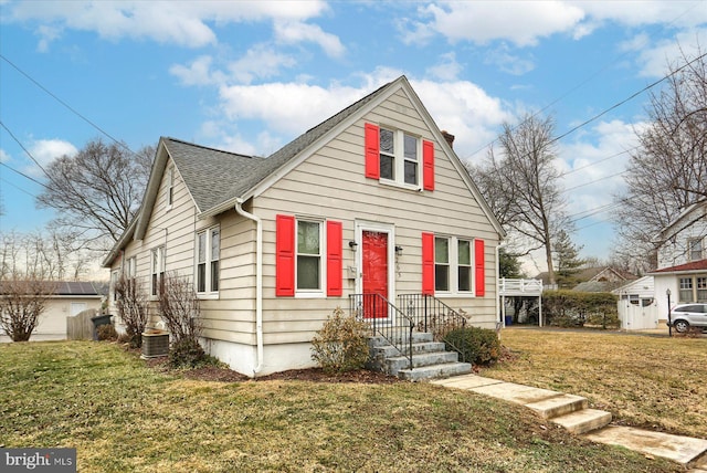 bungalow-style house with a front yard and central air condition unit