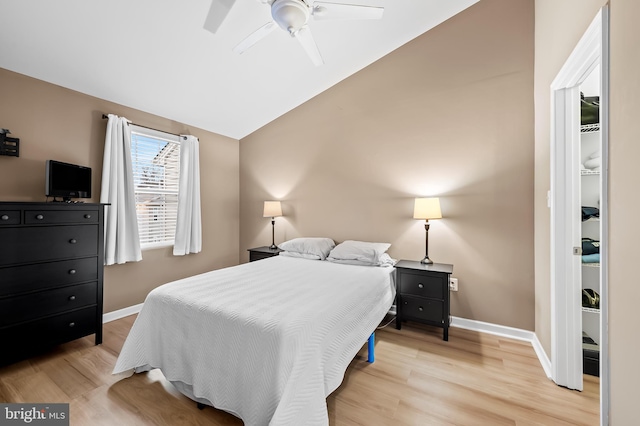 bedroom with ceiling fan, lofted ceiling, and light hardwood / wood-style flooring