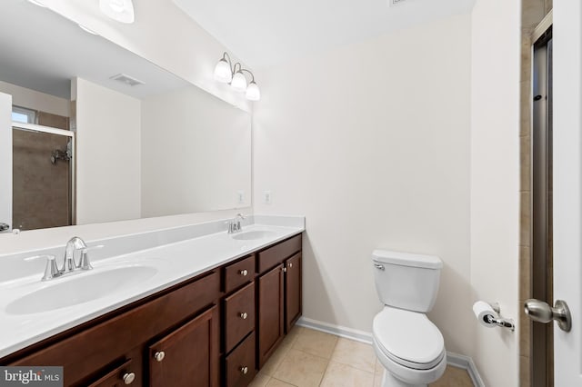 bathroom with tile patterned flooring, vanity, a shower with shower door, and toilet