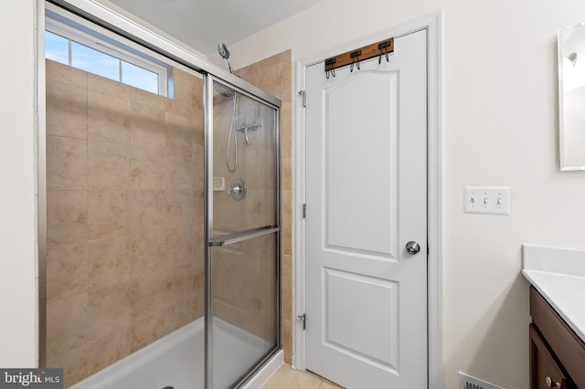 bathroom with vanity and a shower with door