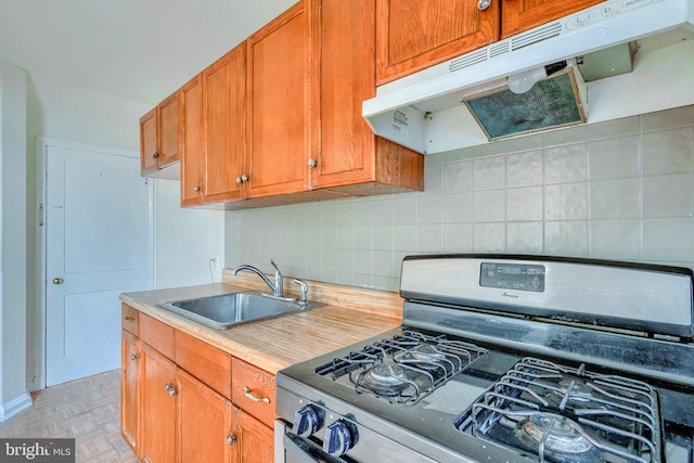 kitchen featuring stainless steel range with gas cooktop, sink, decorative backsplash, and light parquet floors