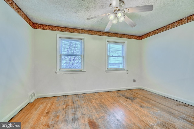 empty room with ceiling fan, light hardwood / wood-style flooring, and a textured ceiling