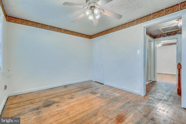 empty room featuring hardwood / wood-style flooring, ceiling fan, and a textured ceiling