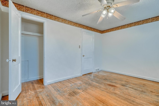 unfurnished bedroom with a closet, ceiling fan, light hardwood / wood-style floors, and a textured ceiling