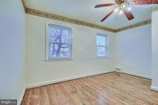 empty room featuring ceiling fan, a textured ceiling, and light hardwood / wood-style floors