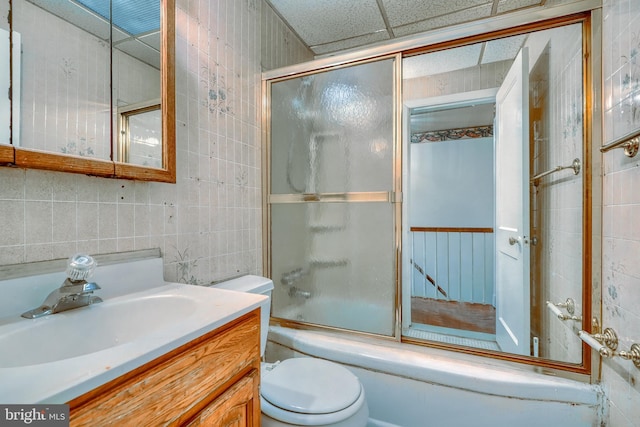 full bathroom featuring tile walls, backsplash, enclosed tub / shower combo, vanity, and toilet