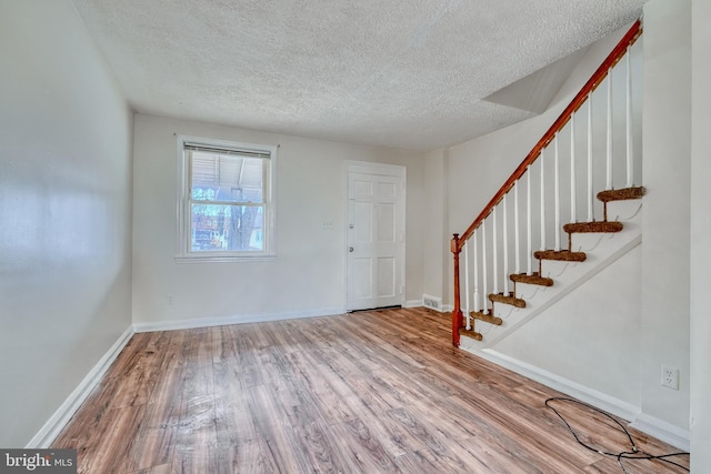 entryway with hardwood / wood-style floors and a textured ceiling