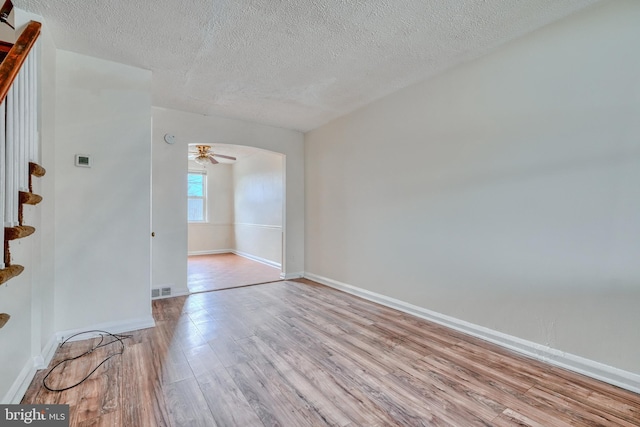 empty room featuring ceiling fan, a textured ceiling, and light hardwood / wood-style floors