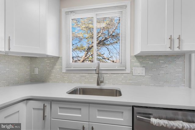 kitchen featuring white cabinetry, dishwasher, sink, and decorative backsplash