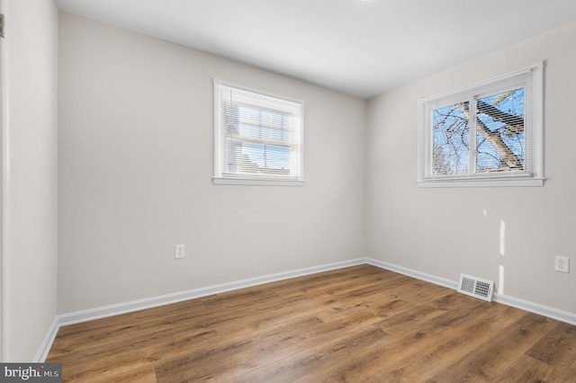 unfurnished room with wood-type flooring