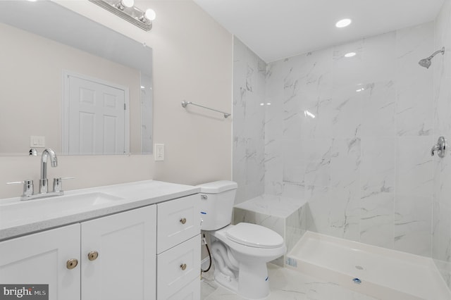 bathroom featuring tiled shower, vanity, and toilet