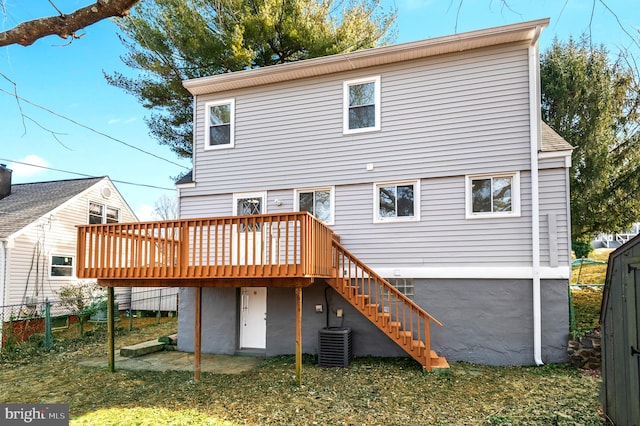 back of house with central AC, a deck, and a shed