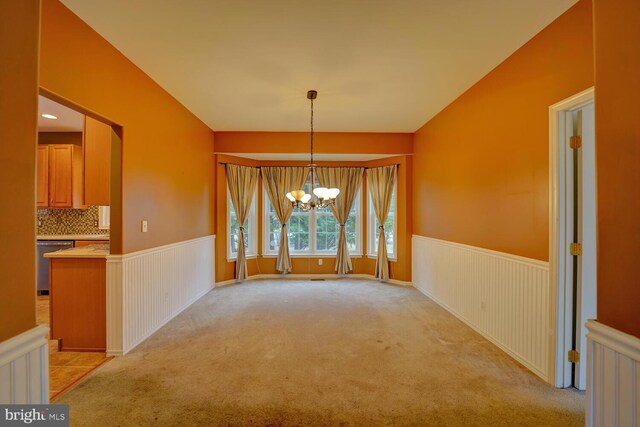 unfurnished dining area with a chandelier and light carpet