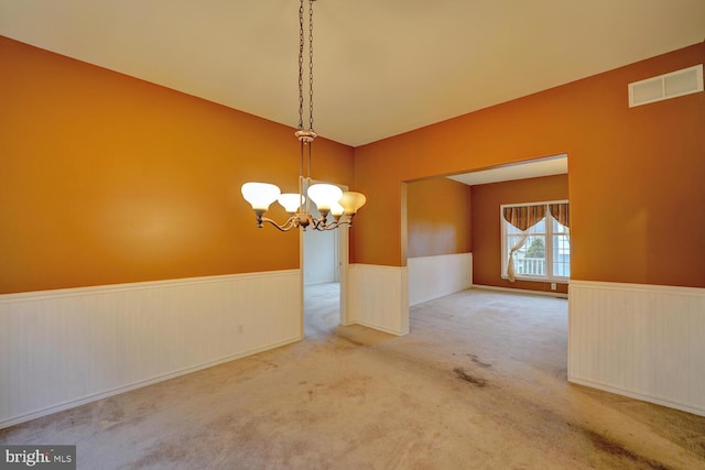 unfurnished dining area featuring light colored carpet and an inviting chandelier