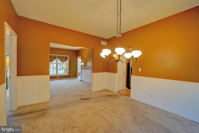 unfurnished dining area featuring a notable chandelier and carpet