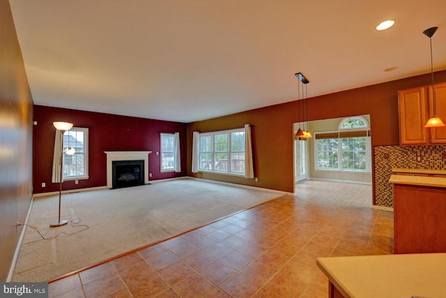 unfurnished living room with a healthy amount of sunlight and light colored carpet