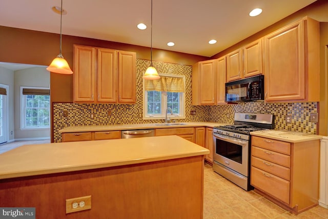 kitchen with tasteful backsplash, sink, decorative light fixtures, and appliances with stainless steel finishes